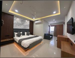 a bedroom with a large bed and a television at Hotel Peacock Anand in Anand
