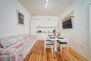 a living room with a couch and a table with chairs at Aura Maris Apartment in Kotor