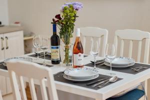 a table with plates and wine bottles and glasses at Aura Maris Apartment in Kotor