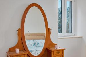 a mirror on a table with a bed in it at Aura Maris Apartment in Kotor
