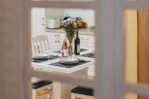 a table with plates and glasses and a vase of flowers at Aura Maris Apartment in Kotor +17 photos