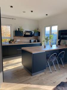 a kitchen with blue cabinets and a wooden counter top at Spa-Villa mit privatem Whirlpool&Sauna und Panoramablick in Wellheim