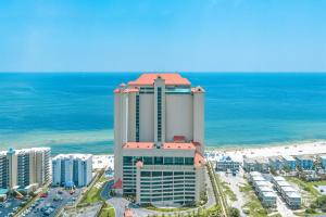 a tall building on the beach next to the ocean at Phoenix West 2207 Upscale Luxury Updated Beachfront Waterslide-Lazy River in Orange Beach