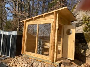 a wooden cabin with a glass door on a pile of rocks at Spa-Villa mit privatem Whirlpool&Sauna und Panoramablick in Wellheim +17 photos