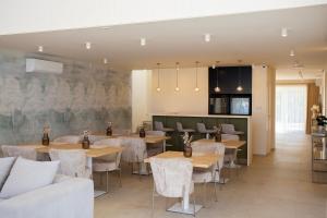 a restaurant with tables and chairs in a room at Kálló Villa in Nagykálló