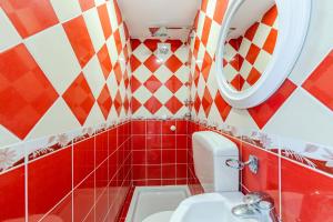a bathroom with a toilet and a mirror at Shiroka Stays in Shirokë