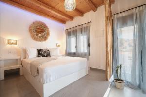 a white bedroom with a bed and a window at Marnik Suites in Kanala