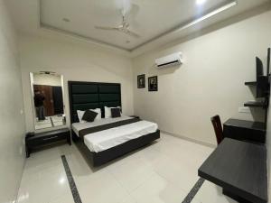 a bedroom with a large bed and a mirror at Hotel Oval Hut in Jalandhar