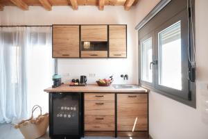 a kitchen with wooden cabinets and a black refrigerator at Marnik Suites in Kanala