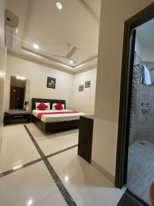 a bedroom with a bed and a bathroom with a shower at Hotel Oval Hut in Jalandhar