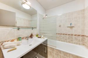 a white bathroom with a sink and a tub at Évasion à deux, studio neuf et design à Tarbes, gare à 700 m, arrivée autonome in Tarbes