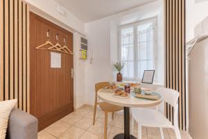 a small kitchen and dining room with a table and chairs at Évasion à deux, studio neuf et design à Tarbes, gare à 700 m, arrivée autonome in Tarbes