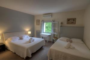 a bedroom with two beds with stuffed animals on them at Logis Hôtel Le Moulin de la Beune in Les Eyzies-de-Tayac +55 photos