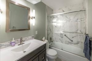 a bathroom with a sink and a toilet and a shower at Spacious 4 BR 3 BA with Fenced Yard in Shawnee +16 photos