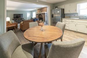 a kitchen and living room with a wooden table and chairs at Spacious 4 BR 3 BA with Fenced Yard in Shawnee
