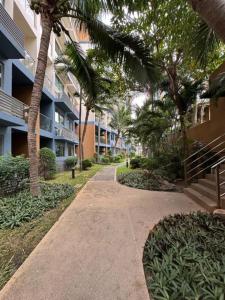 a walkway in front of a building with palm trees at Laguna Beach Resort 2 Pattaya in Jomtien Beach
