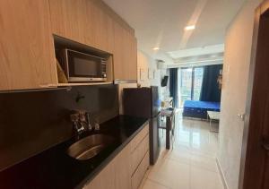 a kitchen with a sink and a microwave above it at Laguna Beach Resort 2 Pattaya in Jomtien Beach