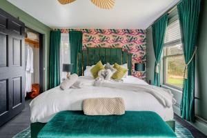a bedroom with a large white bed with green curtains at 2 Fun Homes in Hudson