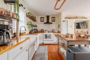 a kitchen with white cabinets and wooden floors at 2 Fun Homes in Hudson