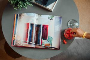 a book on top of a table with a person holding fruit at Casa Mila Loire - L'expérience Hôtel & Spa - Angers Saumur in Saint-Mathurin