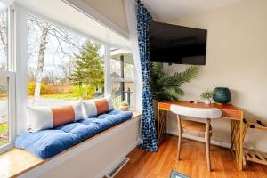 a window seat in a room with a desk and a tv at 2 Fun Homes in Hudson