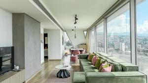 a living room with a green couch and large windows at The Cube 10, 3-BR in Sin El Fil in Beirut
