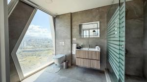 a bathroom with a toilet and a sink and a window at The Cube 10, 3-BR in Sin El Fil in Beirut +33 photos