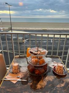 a table with a tray of pastries on a balcony at Hôtel de la Plage in Narbonne