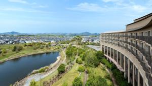 a building next to a river next to a building at ANA Holiday Inn Kobe Sanda by IHG in Sanda