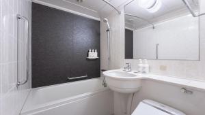 a bathroom with a sink and a toilet and a mirror at ANA Holiday Inn Kobe Sanda by IHG in Sanda