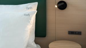 a pillow sitting on a bed next to a wall at ANA Holiday Inn Kobe Sanda by IHG in Sanda
