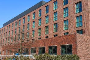 a large red brick building with many windows at Holiday Inn - the niu, Quay Hamburg Harburg by IHG in Hamburg