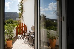 a balcony with a table and a chair and a window at Design studio Two in Palekastron