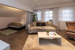 a living room with a couch and a bed at Chiemgauzeit Ferienwohnung - Chiemgau Karte in Inzell