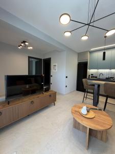 a living room with a table and a tv at Elea Living Chios in Chios