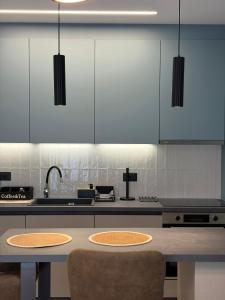 a kitchen with blue cabinets and a table with two chairs at Elea Living Chios in Chios +14 photos
