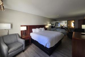 a hotel room with a bed and a chair at OYO Hampton South Carolina Hwy 278 in Hampton-Varnville Airport