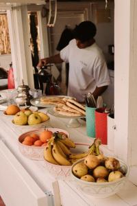 a man standing in a kitchen with a table full of fruit at Surf and Friends in Tamraght Ou Fella