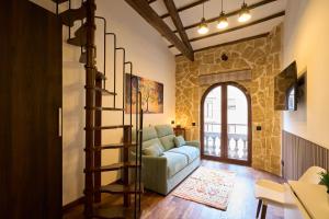 a living room with a couch and a spiral staircase at Los Balcones de San Juan in Salamanca
