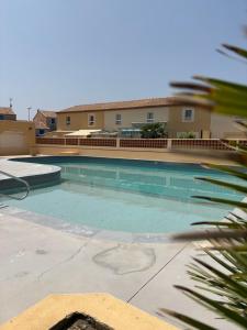 a large swimming pool in front of a building at Au clair soleil in Frontignan