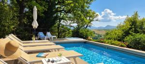 a swimming pool with a table and chairs next to at villa la chiesetta - private pool and Jacuzzi - Borgo Canapegna in Fabriano