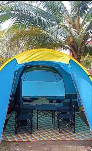 a blue and yellow tent with two chairs in it at Tenda Premium Pantai Madasari in Bulakbenda