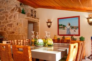 a dining room with a table and a painting on the wall at Casa Justininho in Ponte de Lima
