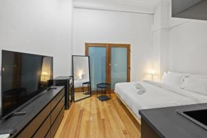 a bedroom with a bed and a desk with a television at South Beach Studio - Simple Base, Walk Everywhere in South Fremantle