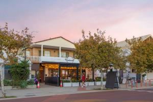 a woman walking down a street in front of a store at South Beach Studio - Simple Base, Walk Everywhere in South Fremantle