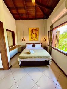 a bedroom with a bed and a painting on the wall at Residencial Villa Cris - Jd. São Lourenço/Itaguaré in Bertioga +169 photos