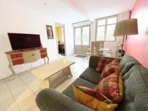 a living room with a couch and a tv at Sérendipity in Marquise