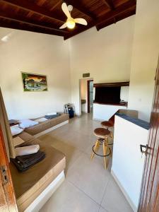 a living room with two beds and a ceiling fan at Residencial Villa Cris - Jd. São Lourenço/Itaguaré in Bertioga
