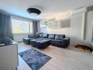 a living room with a couch and a dog at Moderni kolmio Ilmainen Pysäköinti! in Jyväskylä