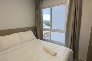 a bed with a book on it next to a window at Edificio Elegance in Foz do Iguaçu